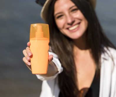 girl smiling while showing the best spf 50 susncreen bottle